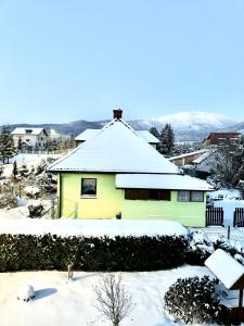 a yellow house with snow on top of it at Domek u podnóża Skrzycznego in Lipowa