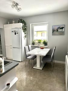 eine Küche mit einem Tisch und einem weißen Kühlschrank in der Unterkunft Domek u podnóża Skrzycznego in Lipowa