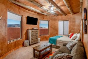 a bedroom with a bed and a couch and a tv at Zion White Bison Glamping & RV Resort in Virgin