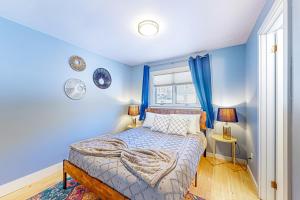 a blue bedroom with a bed and a window at Sugarbush Ski Getaway - Lower in Warren