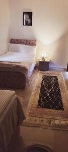 a bedroom with two beds and a rug at Alaa Eldein Pyramids Lights in Cairo