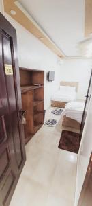 Kleines Zimmer mit 2 Betten und einer Tür in der Unterkunft Alaa Eldein Pyramids Lights in Kairo