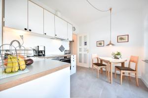 アールベックにあるVilla Germania 14のキッチン(白いキャビネット、テーブル、椅子付)