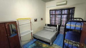 a small room with two bunk beds and a window at Homestay Melewar in Parit Raja