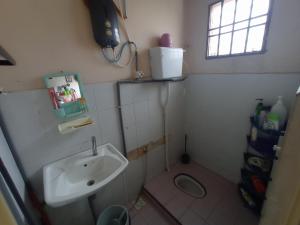 a small bathroom with a sink and a toilet at Homestay Melewar in Parit Raja