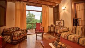 a living room with a couch and a chair and a window at El vergel de la Sierra in Sierra de los Padres