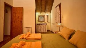 a bedroom with a bed with orange towels on it at El vergel de la Sierra in Sierra de los Padres