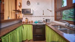 a kitchen with a stove and a sink at El vergel de la Sierra in Sierra de los Padres +43 photos