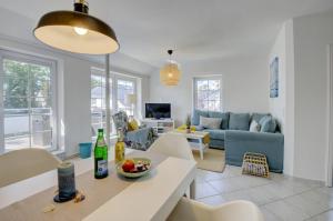 a kitchen and living room with a blue couch at fewo1846 - Duenengras - elegante Maisonettewohnung mit 3 Schlafzimmern und Balkon in Schausende