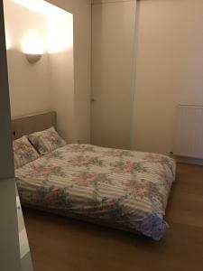 1 dormitorio con 1 cama con colcha de flores en Marie, en Lier