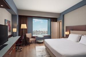 a hotel room with a bed and a desk and a window at Delta Hotels Istanbul West in Istanbul