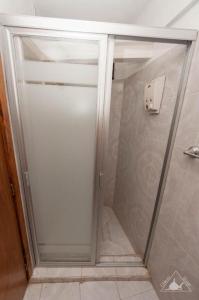 W łazience znajduje się prysznic ze szklanymi drzwiami. w obiekcie El Hogar de Carmelita w mieście Guanajuato