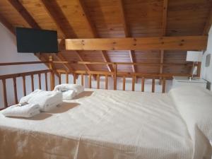 a large white bed in a room with wooden ceilings at Amaneceres frente al Mar Dpto 2 in Puerto Madryn