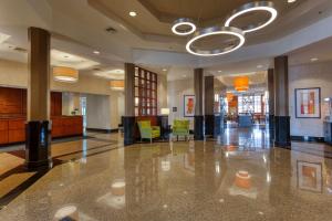 een lobby met een grote lobby met stoelen en een plafond bij Drury Inn & Suites Indianapolis Northeast in Indianapolis