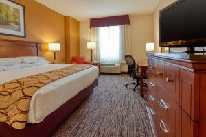 um quarto de hotel com uma cama e uma televisão de ecrã plano em Drury Inn & Suites Indianapolis Northeast em Indianápolis