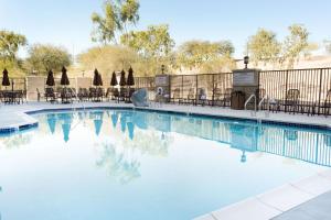 a swimming pool with chairs and a slide at Drury Inn & Suites Phoenix Tempe in Tempe