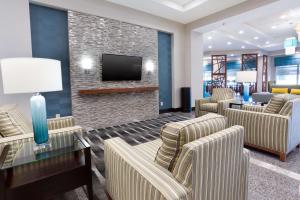 Drury Inn & Suites Burlington في برلنغتون: غرفة انتظار مع كراسي وتلفزيون بشاشة مسطحة