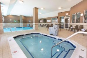 einen Pool in einem Hotelzimmer mit Stühlen und Tischen in der Unterkunft Drury Inn & Suites Burlington in Burlington