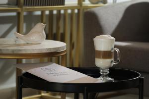 voco Saltillo Suites, an IHG Hotel في سالتيلو: صينية مع مشروب على طاولة بجوار كرسي