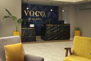 a lobby with two chairs and a yoga sign at voco Saltillo Suites, an IHG Hotel in Saltillo