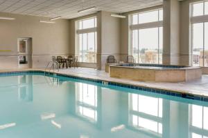 a swimming pool with a tub and windows at Drury Plaza Hotel Cape Girardeau Conference Center in Cape Girardeau