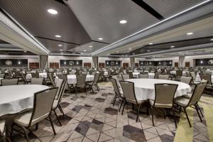 een grote feestzaal met witte tafels en stoelen bij Drury Plaza Hotel Cape Girardeau Conference Center in Cape Girardeau