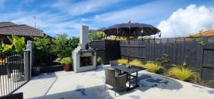 a patio with a table and an umbrella at Sunkist B & B in Papamoa