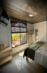 Habitación pequeña con cama y ventana en Casa Bambohemia, en Miravalles