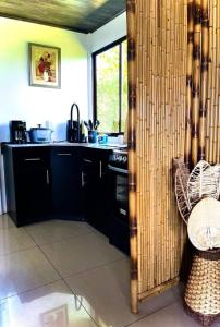 eine Küche mit schwarzen Schränken und einem schwarzen Herd in der Unterkunft Casa Bambohemia in Miravalles