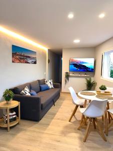 sala de estar con sofá, mesa y sillas en Apartamento El Faro del Cabezo en Arona