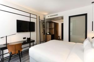 a bedroom with a bed and a desk and a tv at Radisson Hotel Tunis, City Center in Tunis