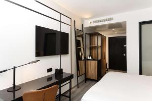 um quarto com uma cama e uma televisão na parede em Radisson Hotel Tunis, City Center em Tunes