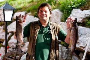 a man holding two fish in his hands at Almidylle Sabathy in Obdach