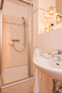 ein Bad mit einem Waschbecken und einer Dusche in der Unterkunft Dünenresidenz - Ferienwohnung 13 "Sandburg" in Juliusruh
