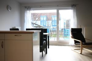 a room with a table and chairs and a large window at Kurparkcarree - Ferienwohnung Meeresbrise in Juliusruh