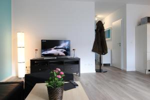 a living room with a couch and a flat screen tv at Kurparkcarree - Ferienwohnung Meeresbrise in Juliusruh