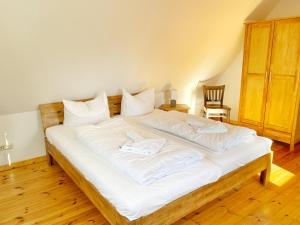 ein großes weißes Bett mit weißer Bettwäsche und Kissen in der Unterkunft Hofgut Bisdamitz - Ferienhaus "Alte Mühle" in Bisdamitz