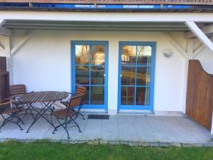 a patio with a table and chairs in front of a house at Ferienwohnungen in der Ferienanlage Kap Arkona in Putgarten