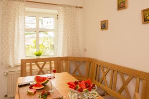 a table with a glass of wine and a bowl of watermelon at Ferienhaus am Ufer - Ferienwohnung Strandsand in Sassnitz