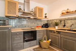 a kitchen with gray cabinets and a sink at Ferienhaus am Ufer - Ferienwohnung Strandsand in Sassnitz +4 photos