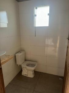 a bathroom with a toilet and a window at Cantinho da Alegria in Raul Soares