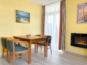 a dining room with a table and chairs and a fireplace at Ferienwohnung 10 "Bootsmann Hannes" in Wiek auf Rügen