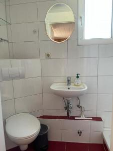 La salle de bains est pourvue de toilettes, d'un lavabo et d'un miroir. dans l'établissement Krabbenfischer, à Timmendorfer Strand