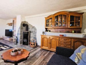 a living room with a kitchen with a fireplace at Ferienwohnung Am Bergmannsbrunnen in Schönheide