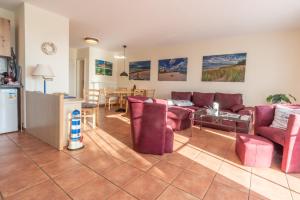 a living room with red furniture and a kitchen at Neddesitz Ferienappartement Nr 51 in Neddesitz