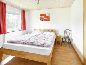 ニーンドルフにある_BIR16_ Villa Bullerbueのベッドルーム1室(ベッド1台、椅子、窓付)