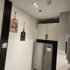 uma cozinha com um frigorífico de aço inoxidável e armários em Twin Hearts 328 em Roxas City