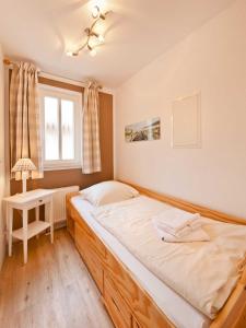 a bedroom with a large bed and a window at _ARW3_ _ Ferienwohnung Kossmann in Niendorf
