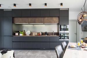 a kitchen with black cabinets and a dining table at _ERL41_ PIER 41 in Niendorf