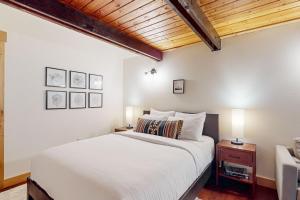 um quarto com uma cama branca e um tecto de madeira em Creekside Cabin em Rhododendron